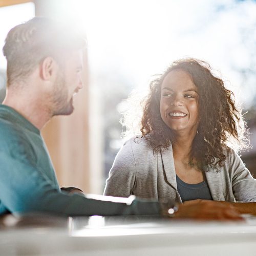 Happy African American woman talking to her male friend during a class at the university.