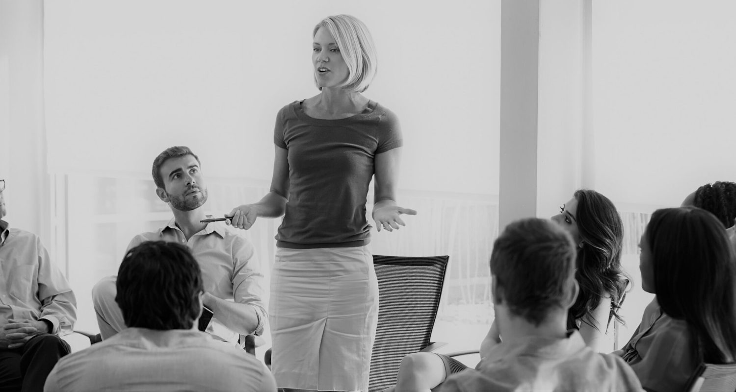 Businesswoman Addressing Multi-Cultural Office Staff Meeting In Smart/Casual Dresswear