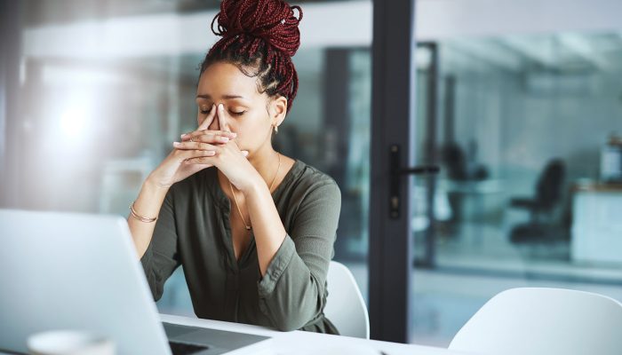 Shot of a young businesswoman looking stressed out while working in an office