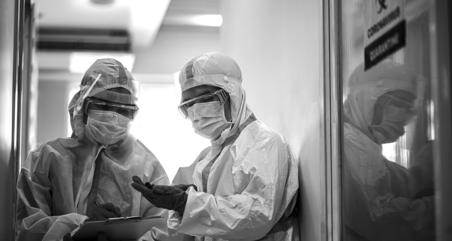 Asian doctor holding checking coronavirus or covid-19 infected patient name list sheet in quarantine area in hospital