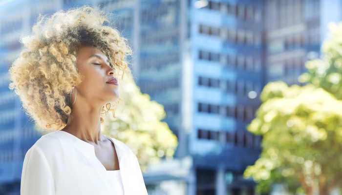 Beautiful businesswoman relaxing outdoor with blue building in the background