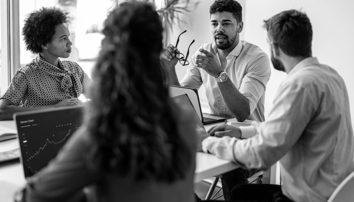 Confident and successful team. Group of young modern people in smart casual wear discussing business while sitting in the creative office