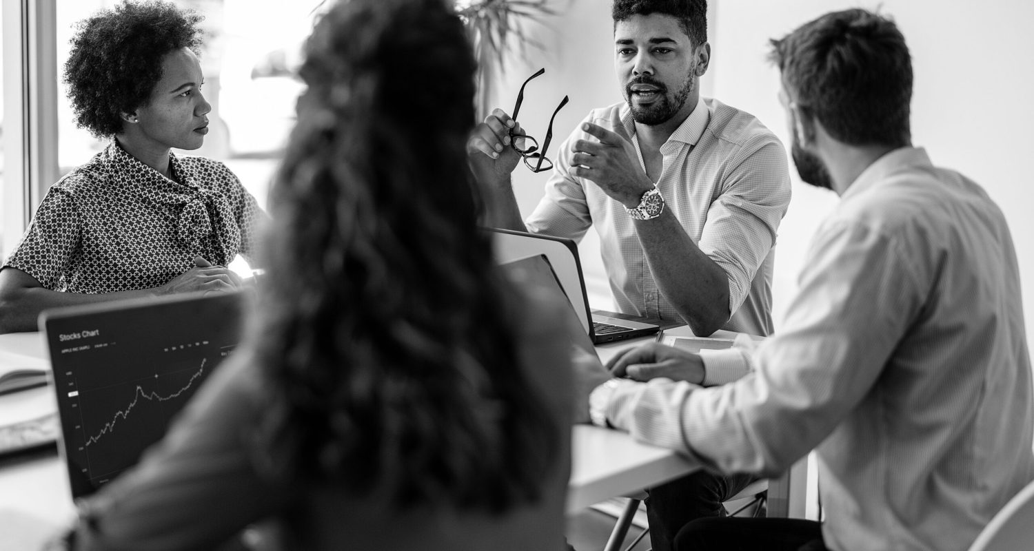 Confident and successful team. Group of young modern people in smart casual wear discussing business while sitting in the creative office