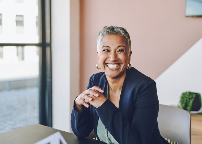 Senior, happy and smile of a proud corporate woman ceo of a company at her office desk. Portrait of a business leader, manager and boss feeling worker, career and management success at a company