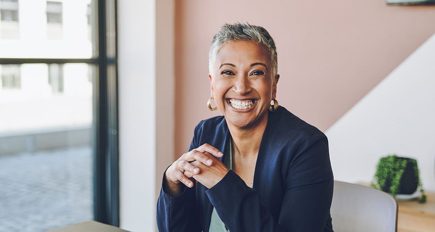 Senior, happy and smile of a proud corporate woman ceo of a company at her office desk. Portrait of a business leader, manager and boss feeling worker, career and management success at a company