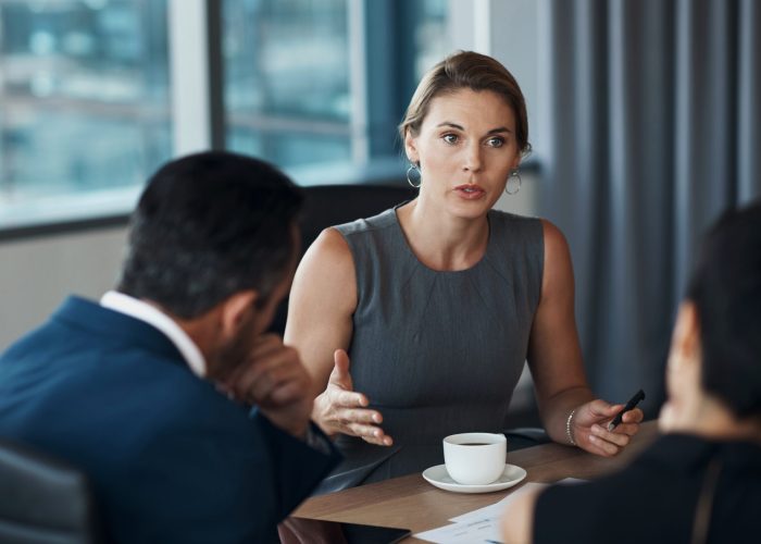 Serious woman talking to business clients in meeting negotiation, legal advice or professional advisory planning. Lawyer, manager or corporate people in conference room discussion for career strategy