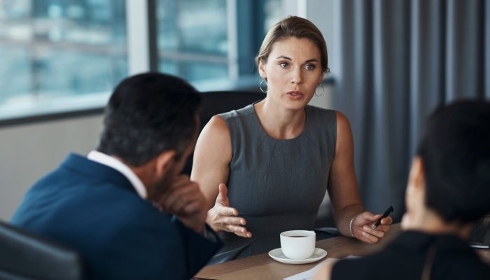 Serious woman talking to business clients in meeting negotiation, legal advice or professional advisory planning. Lawyer, manager or corporate people in conference room discussion for career strategy