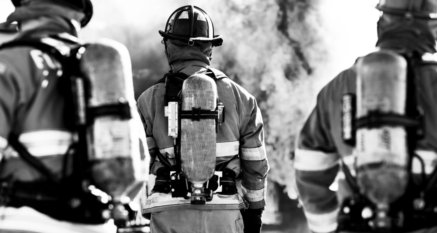 Three firefighters putting out an house fire. Horizontal shot.