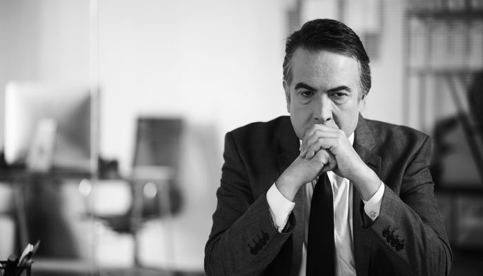 Portrait of stressed tired lawyer sitting at office desk thinking about difficult case