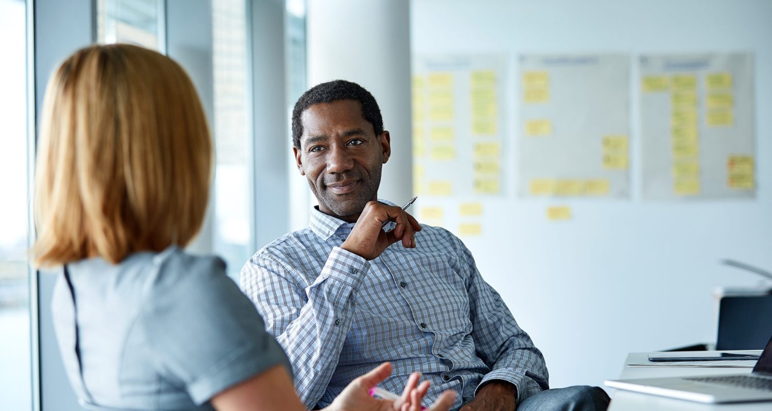 Shot of two colleagues talking together in a modern office