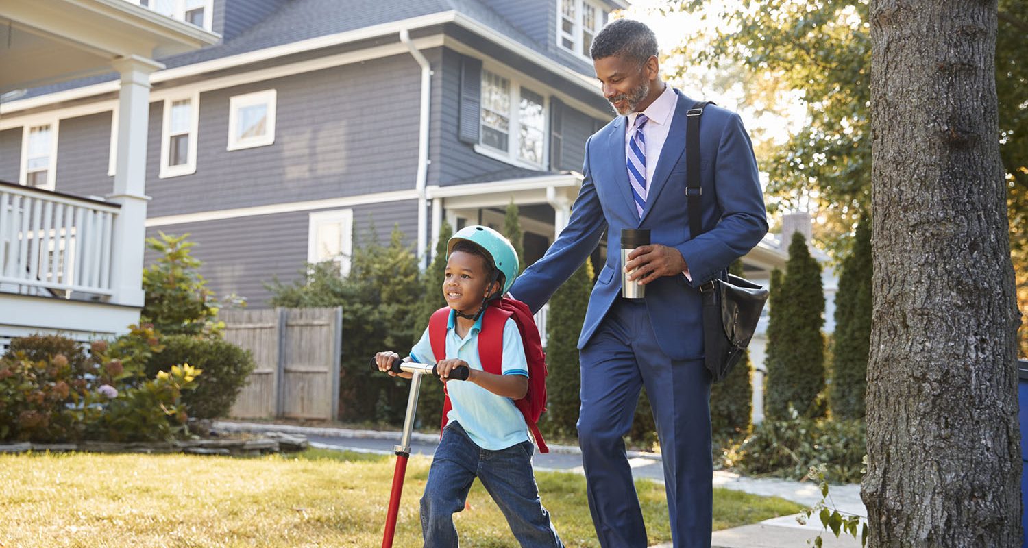 Businessman Father Walking Son On Scooter To School